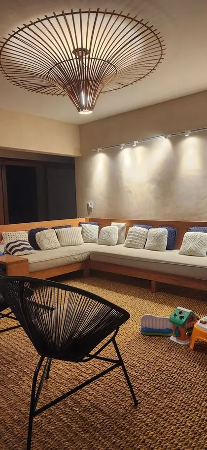 Estar interior con banco de obra, almohadones y lámpara de fibra